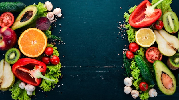 Gesundes Essen Gemüse und Obst auf einem schwarzen Hintergrund aus Holz Draufsicht Kopieren Sie Platz