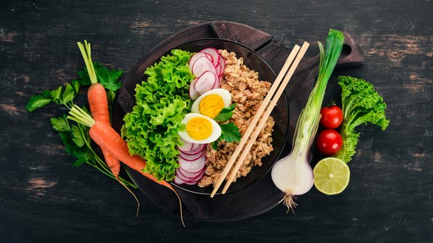 Gesundes Essen Haferflocken Salat Rettich Ei Auf einem hölzernen Hintergrund Ansicht von oben Freier Kopierraum