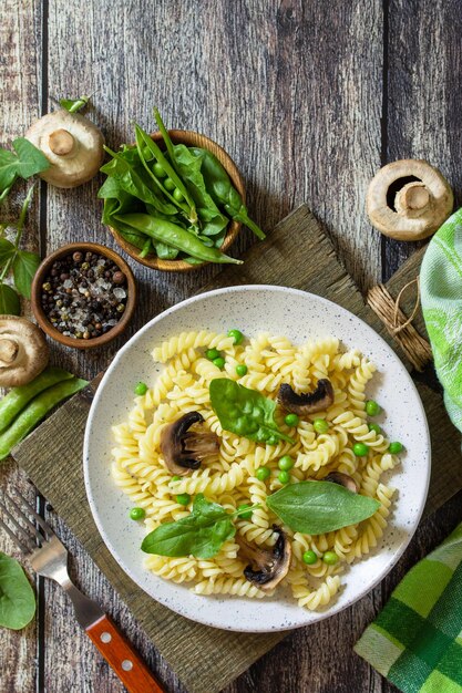 Gesundes Essen Hausgemachte Pasta Fusilli mit grünen Erbsen und gegrillten Champignons Draufsicht Kopieren Sie Platz