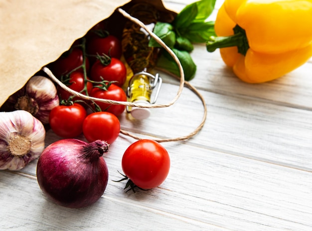 Gesundes Essen in Papiertüte auf einer weißen Holzoberfläche