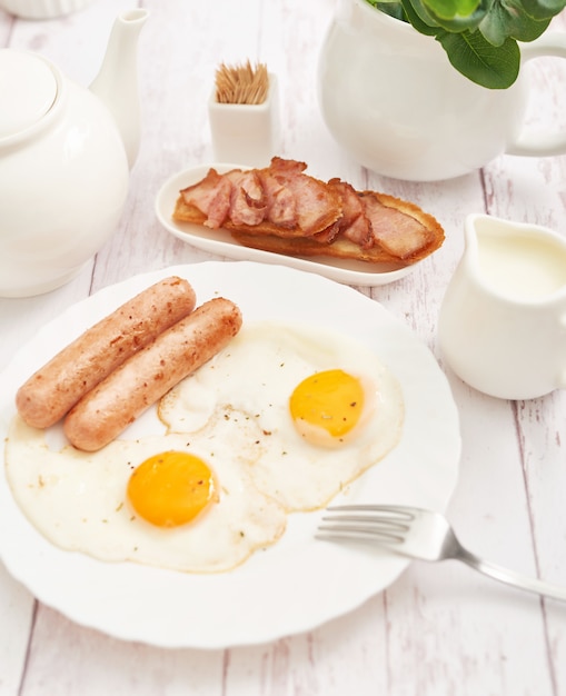 Gesundes Essen. Kontinentales Frühstück im Hotelzimmer oder im Bett. Spiegeleier mit Würstchen. Tasse Kaffee. Menüvorlage. Kochen. Kochen. Romantisches französisches oder ländliches Frühstück am Valentinstag.