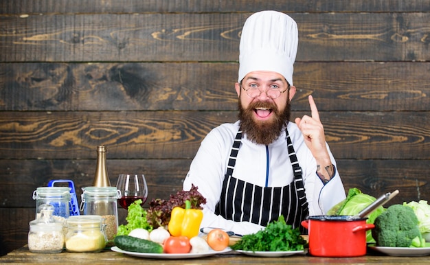 Gesundes Essen und Vegetarier Glücklicher Mann, der in der Küche kocht Professioneller Koch in Kochuniform Diät mit Bio-Lebensmitteln Frisches Gemüse Vitaminmann verwendet Küchenutensilien Ernährungswahl treffen