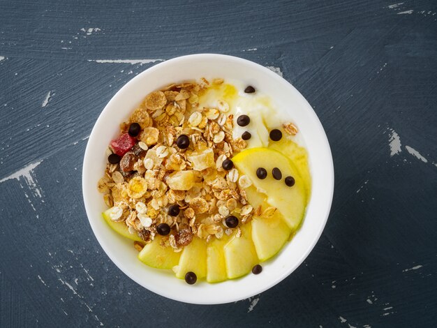 Gesundes Frühstück am Morgen - Joghurt und Müsli, Haferflocken mit Obst und Honig,