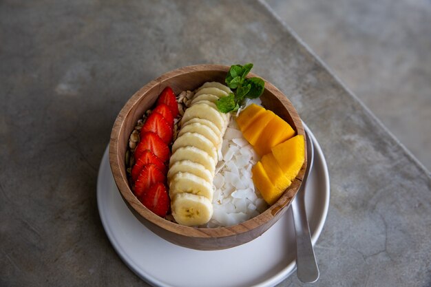 Gesundes Frühstück aus Smoothie Bowl in Holzschale mit frischen Früchten