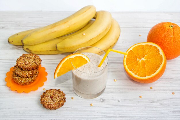 Gesundes Frühstück. Bananen-Smoothie mit Orangenscheibe, Kekse aus Sonnenblumenkernen, Sesam und Honig