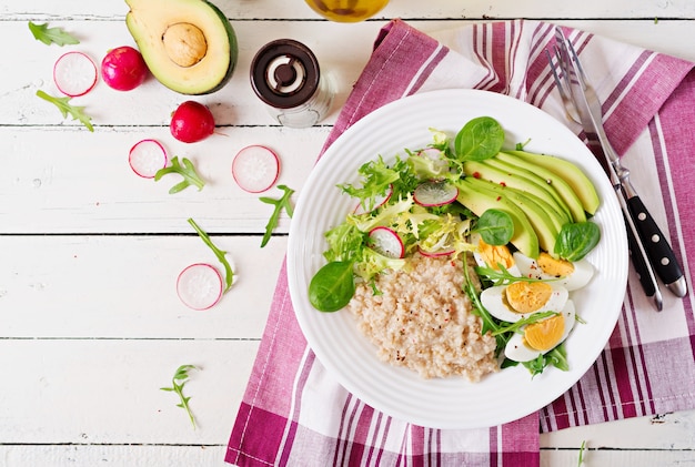 Gesundes Frühstück. Diätmenü. Haferbrei und Avocadosalat und Eier. Ansicht von oben