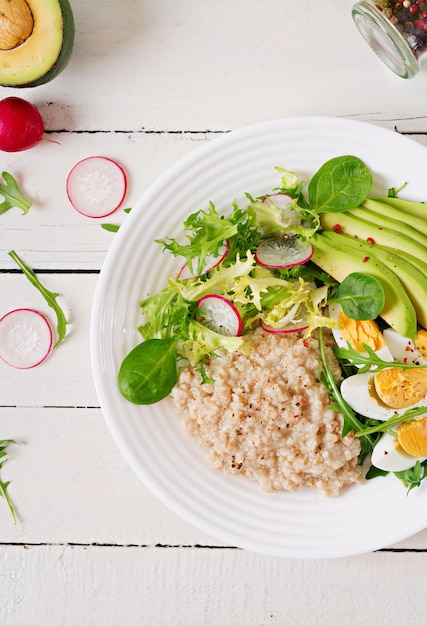 Gesundes Frühstück. Diätmenü. Haferbrei und Avocadosalat und Eier.