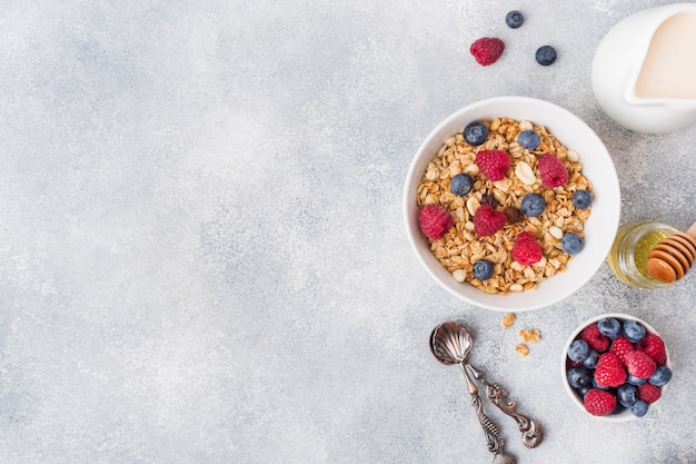 Gesundes Frühstück. Frisches Müsli, Müsli mit Joghurt und Beeren auf grauem Hintergrund. Kopieren Sie Platz