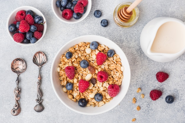 Gesundes Frühstück. Frisches Müsli, Müsli mit Joghurt und Beeren auf grauem Hintergrund.