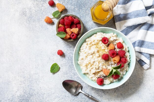 Gesundes Frühstück Haferbrei in einer Keramikschüssel, geschmückt mit frischen Beeren und Himbeeren