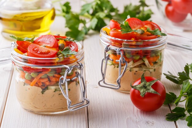 Gesundes Frühstück - Hummus mit Gemüse in Gläsern.