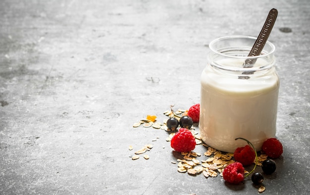 Gesundes Frühstück . Milchcreme mit Müsli und Beeren. Auf dem Steintisch.