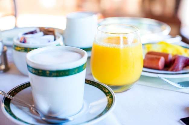 Gesundes Frühstück mit frischem Saft und süßem Hörnchen im Restauranterholungsort im Freien