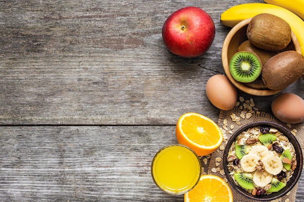 Gesundes Frühstück mit Hafer, Obst, Beeren, Ei und Orangensaft