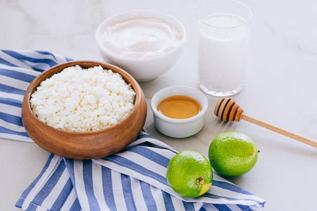 Gesundes Frühstück mit Hüttenkäse mit Sauerrahm, Honig und Limette auf einem Marmortisch