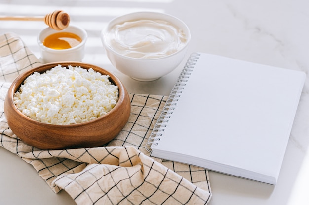 Foto gesundes frühstück mit hüttenkäse mit saurer sahne und honig, sauberes leerzeichen für ihren text, diätplan auf einem marmortisch