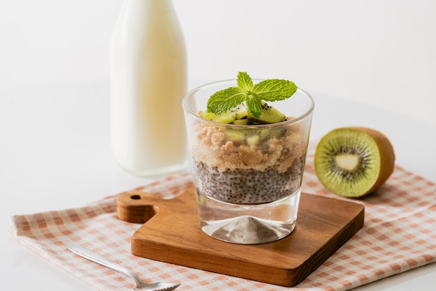 Gesundes Frühstück mit Joghurt, Nuss, Kiwi und Chiasamen. Schüssel mit frischem Obst.