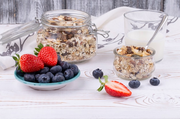 Gesundes Frühstück mit Müsli und frischen Erdbeeren und Blaubeeren