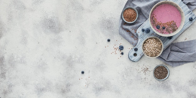 Gesundes Frühstück mit rosa Joghurt-Smoothie-Schüssel aus Beeren und Samen