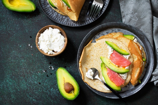 Gesundes Frühstück oder Snack Haferpfannkuchen gefüllt mit Hüttenkäse, Lachs und Avocado