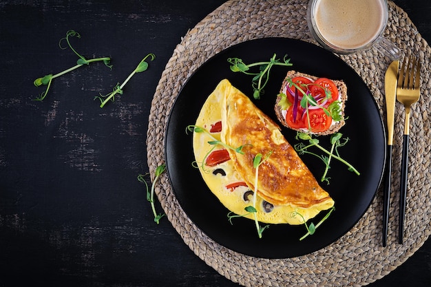 Gesundes Frühstück Omelette mit Tomaten, Käse und Oliven Sandwich mit Frischkäse und Tomate Draufsicht