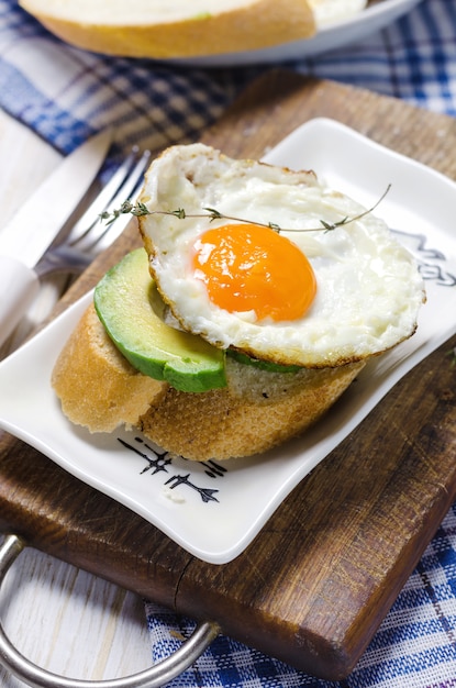 Gesundes Frühstück. Sandwich mit Roggenbrot, Avocado und Spiegeleiern