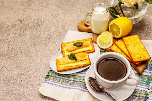 Gesundes Frühstück. Tasse Kaffee (schwarzer Tee), Milch, Cracker mit Butter und Lachs