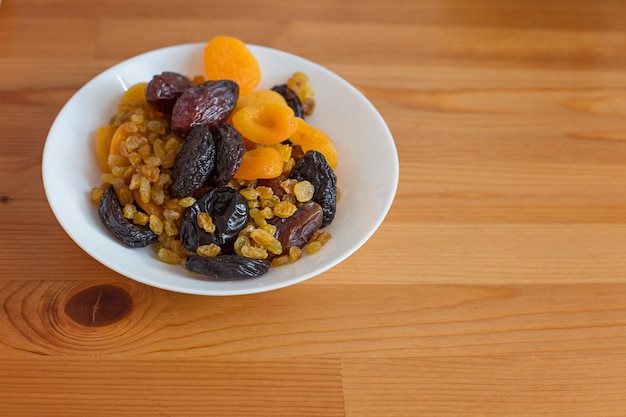 Gesundes Frühstück und Snacks. Weißer Teller mit Trockenfrüchten