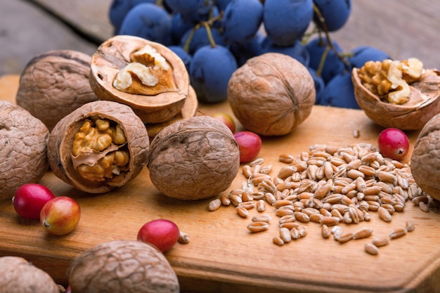 Gesundes Frühstück Weizen Haferflocken Preiselbeeren Nüsse Trauben auf einem Holztisch xA