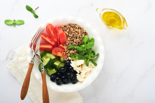 Gesundes Gemüse-Mittagessen aus der Buddha-Schüssel mit Tomaten-Gurken-Mozzarella-Käse-Quinoa-Oliven und Microgreens Veganer Salat-Buddha-Schüssel Gesundes und ausgewogenes Ernährungskonzept