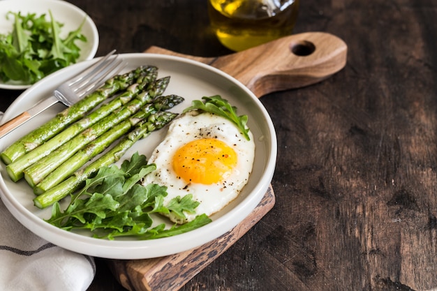 Gesundes hausgemachtes Frühstück mit Spargel, Spiegelei und Rucola. Konzept der gesunden Ernährung unter Quarantäne. Ketodiät