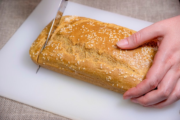 Gesundes hausgemachtes glutenfreies Brot für eine Bio-Ernährung von Hand schneiden