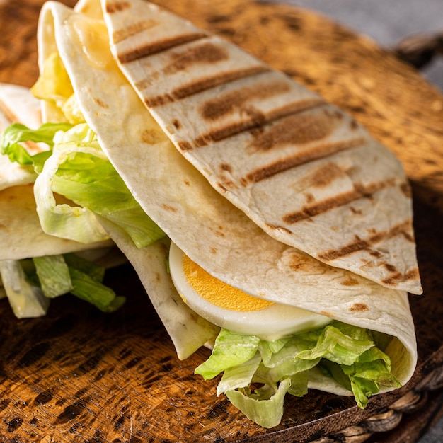 Foto gesundes hausgemachtes tortilla-wrap mit frisch zubereitetem grünen caesar-salat