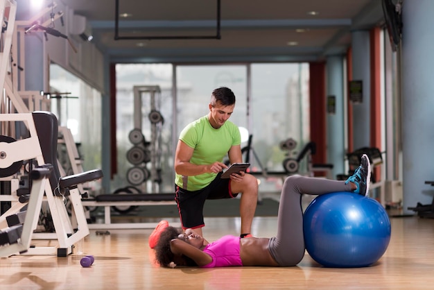 gesundes junges paar trainiert im fitnessstudio pilates-training mit persönlichem trainer