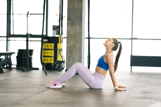 Gesundes junges weibliches Sitzen entspannt nach dem Training im Fitnessstudio