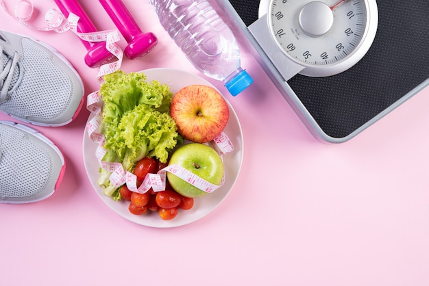 Gesundes Lebensstil-, Lebensmittel- und Sportkonzept auf rosa Pastell.