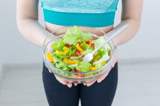 Gesundes Lebensstil- und Diätkonzept - Nahaufnahme der Frau, die einen vegetarischen Salat zeigt