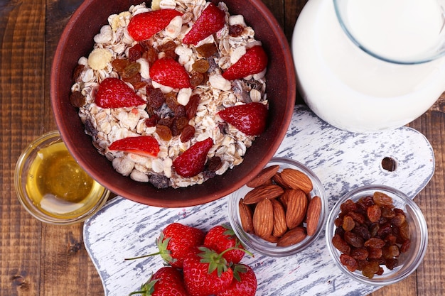 Gesundes Müsli mit Milch und Erdbeere auf Holztisch