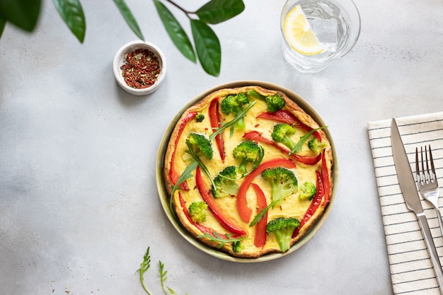 Gesundes Omelett aus Brokkoli und Paprika auf einem vegetarischen Frühstück mit grauem Betonhintergrund, horizontal, Kopienraum