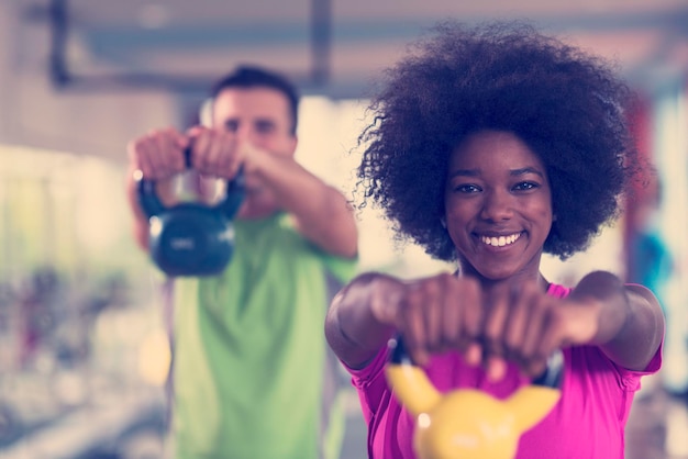 gesundes paar training mit gewichten hanteln im crossfit gym afroamerikanerin mit afrofrisur