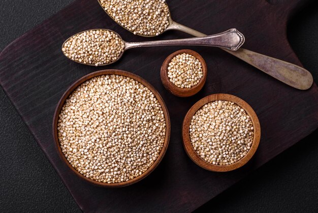 Gesundes rohes Quinoa in einer Schüssel auf einem dunklen Betongrund