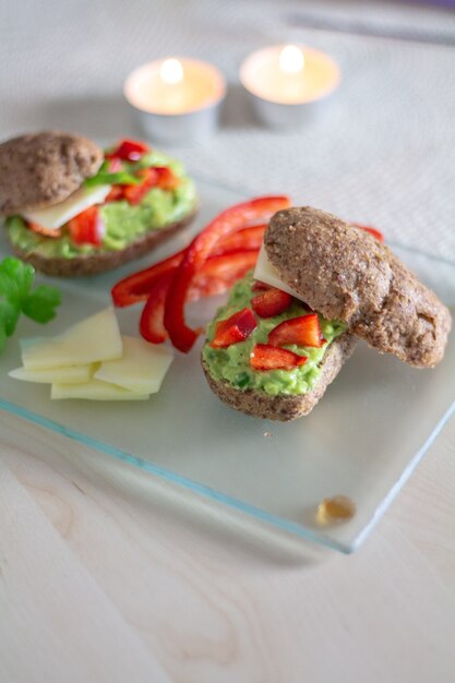 Gesundes Sandwich mit Avocado und Käse auf dem Glasbrett