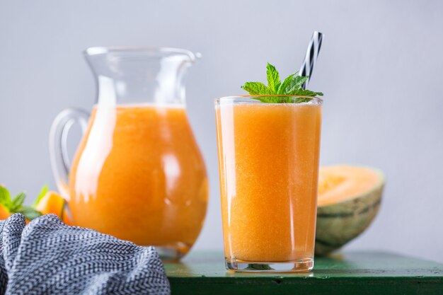 Gesundes, sauberes Essen, Diät und Ernährung, saisonales, sommerliches Frühstückskonzept. Frischer Bio-Melonen-Cantaloupe-Smoothie auf einem Küchentisch.