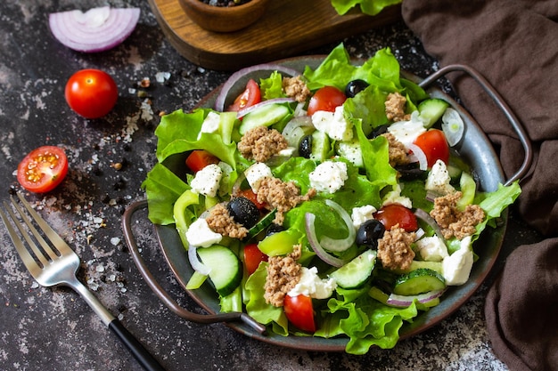 Gesundes sommermittagessen griechischer salat mit thunfischgemüse und salat auf einer steinplatte