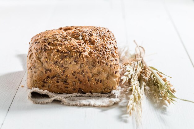 Gesundes und frisches Brot mit mehreren Körnern auf weißem Tisch