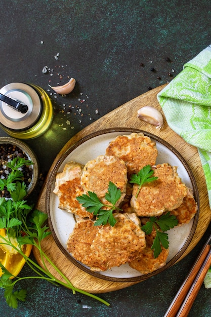 Gesundes veganes Essen Rote Fischkoteletts auf einem dunklen Stein- oder Schiefertisch Draufsicht Kopierbereich