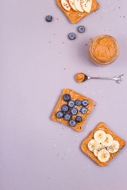 Gesundes vegetarisches Frühstück mit Erdnussbutter, Obst und Superfoods.