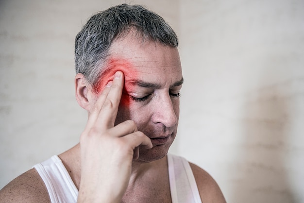 Gesundheit, Schmerz, Stress, Alter und Menschen Konzept -Matur Mann leiden unter Kopfschmerzen zu Hause. Mann berührt Stirn. Negative menschliche Emotionen Gesichtsausdruck Gefühl