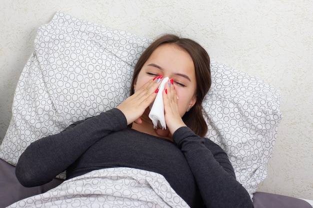 Gesundheit und Medizin. Ein junges Mädchen liegt krank zu Hause im Bett.