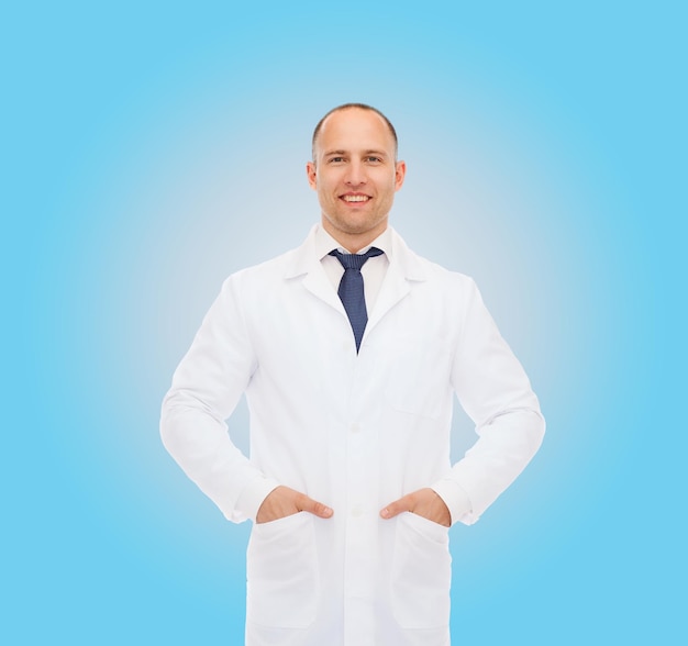 gesundheits-, berufs- und medizinkonzept - lächelnder männlicher arzt im weißen kittel über blauem hintergrund